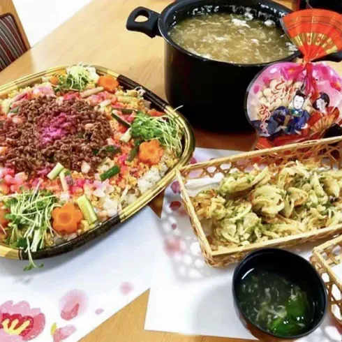 華やかなイベント食。飾り切りの野菜が乗ったちらし寿司、天ぷら、雛あられ